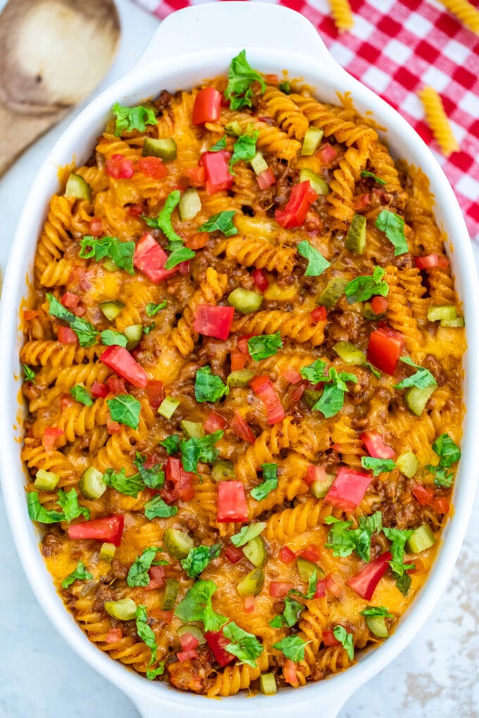 Cheeseburger casserole with rigatoni pasta topped with chopped tomatoes and pickles