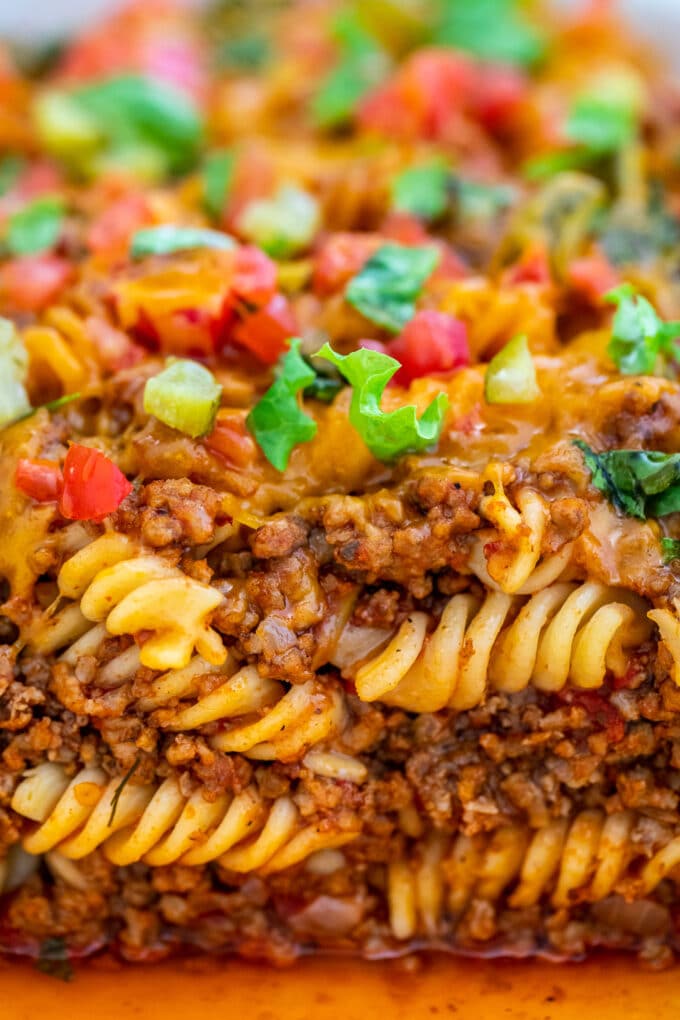 A slice of juicy cheeseburger Casserole topped with green onion