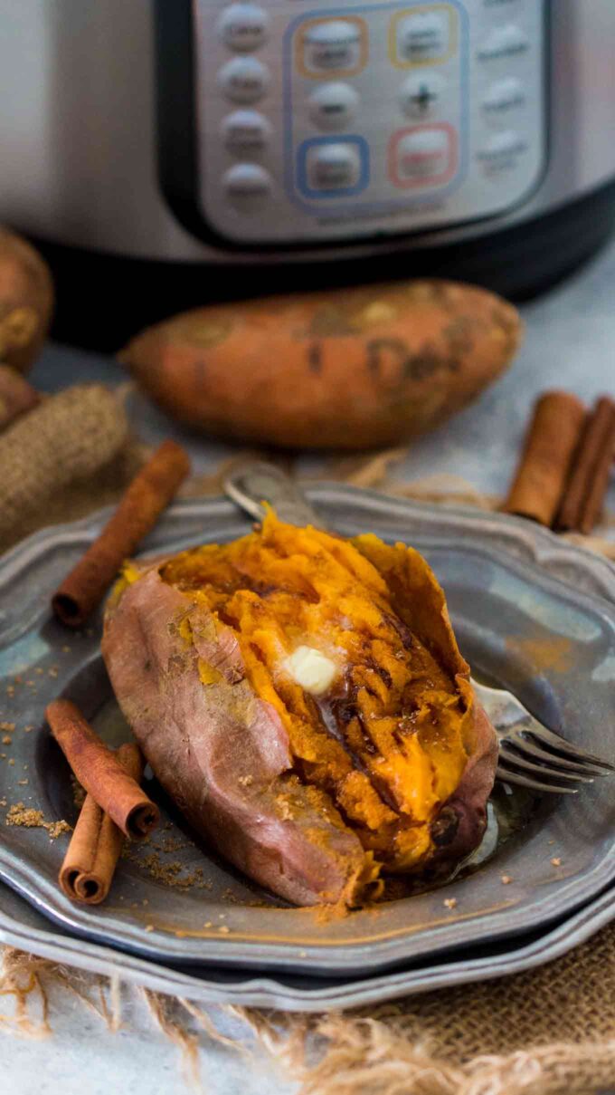 Cooked Sweet potatoes in the instant pot on a silver plate topped with butter and cinnamon 