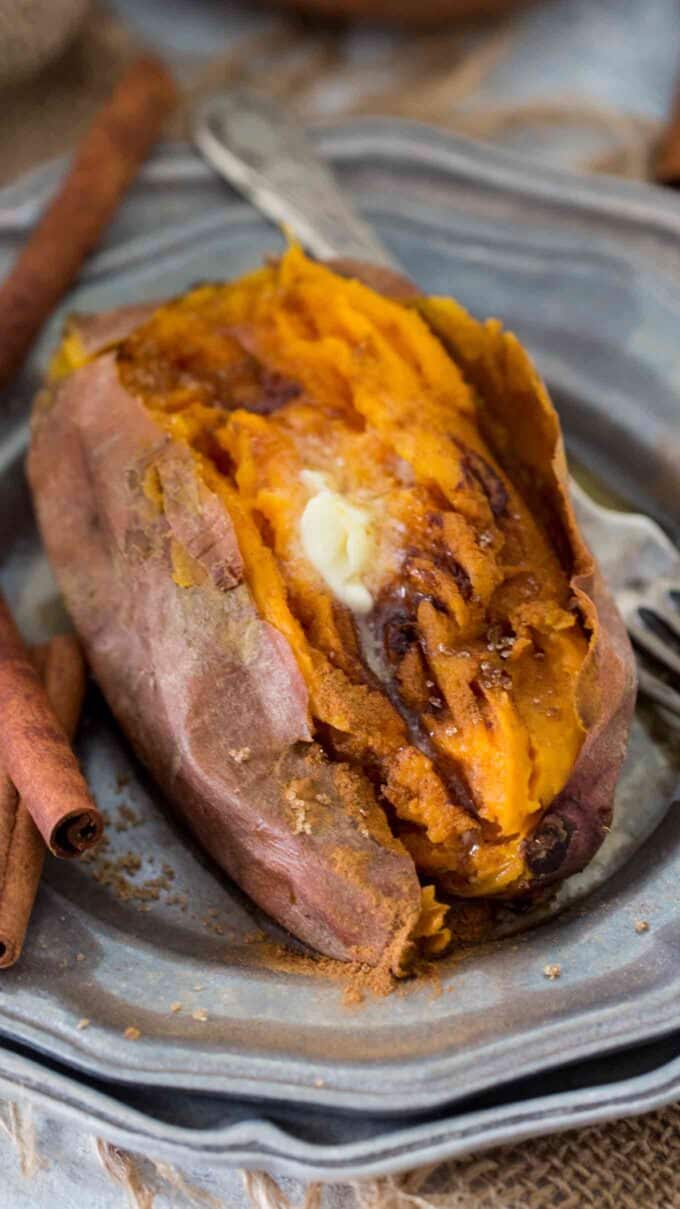 baked sweet potatoes topped with butter and brown sugar on a plate