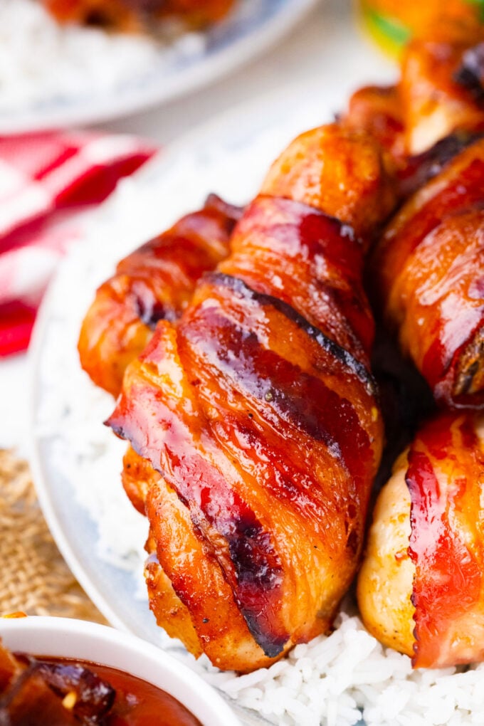 Brown sugar glazed bacon wrapped chicken drumsticks over rice.