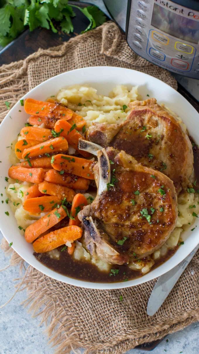 Image of instant pot pork chops with carrots and mashed potatoes. 