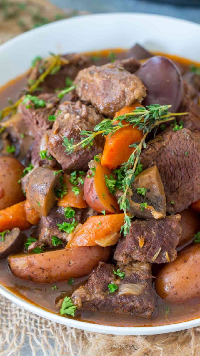 beef bourguignon with veggies and fresh herbs on a plate