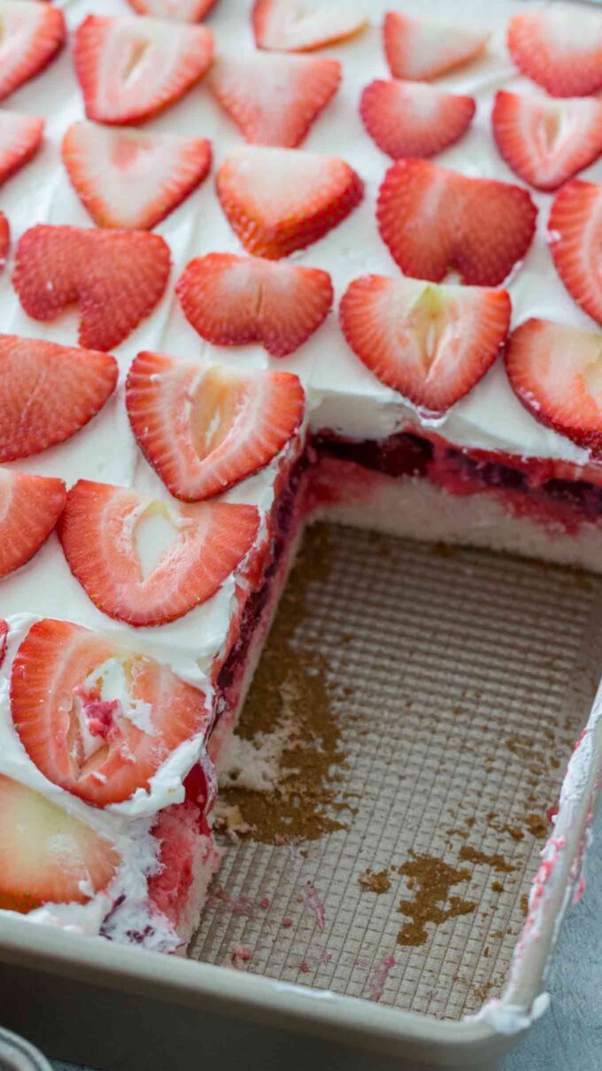 image of strawberry cake topped with sliced strawberries on a baking pan