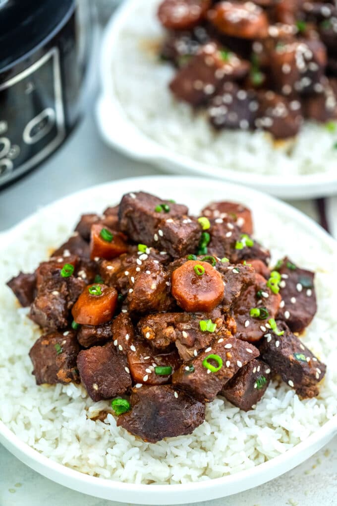 Image of slow cooker beef teriyaki garnished with sesame seeds over white rice.