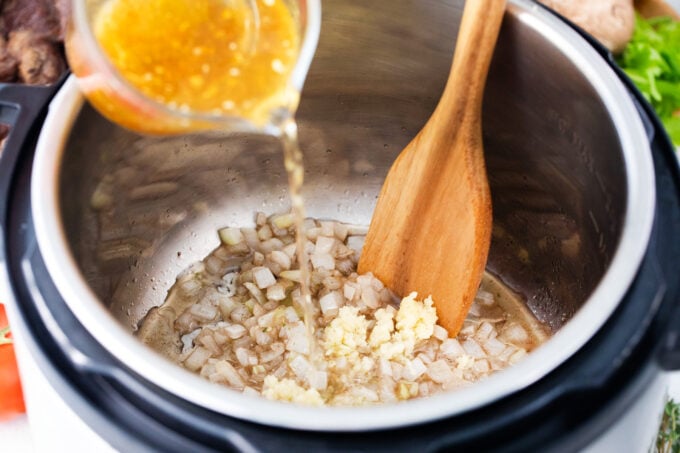 Deglazing the Instant Pot with beef broth.