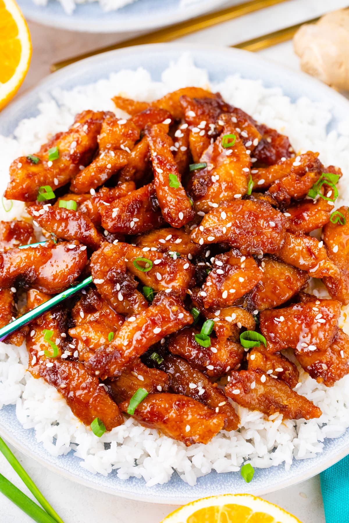 Overhead shot of homemade crispy ginger sesame chicken over rice.