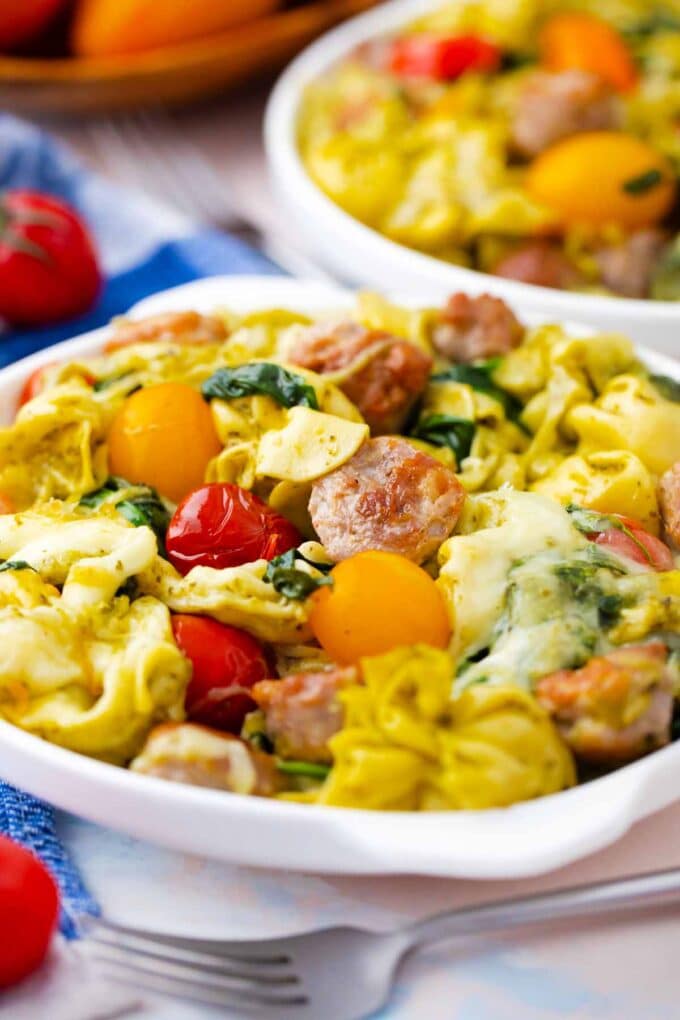 two plates of sausage pesto tortellini casserole