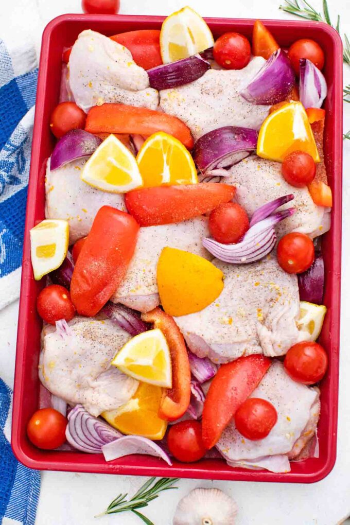overhead shot of raw chicken thighs in a pan with veggies