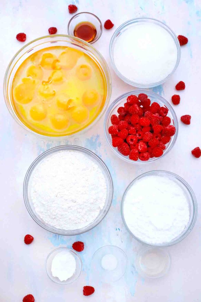 overhead shot of eggs raspberries sugar in bowls on a table