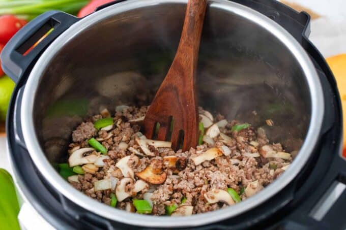 ground beef, sliced onion and diced green bell pepper in the instant pot