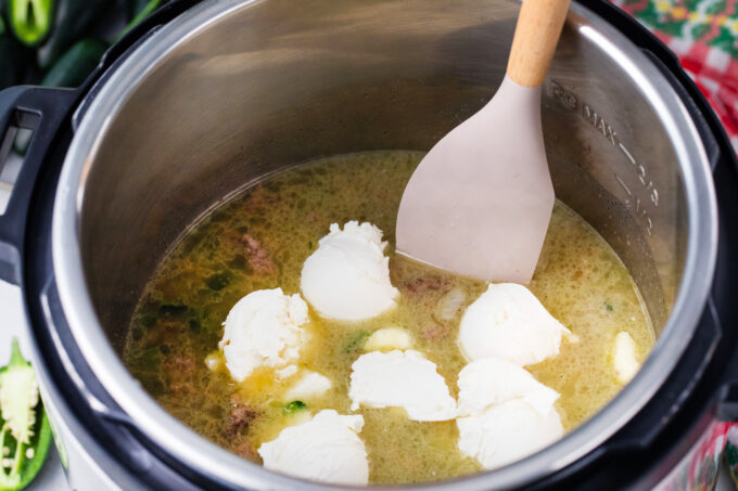 Adding cream cheese to instant pot jalapeno popper pasta.
