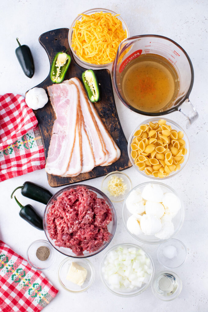 Overhead shot of instant pot jalapeno popper pasta ingredients arranged on a white surface.