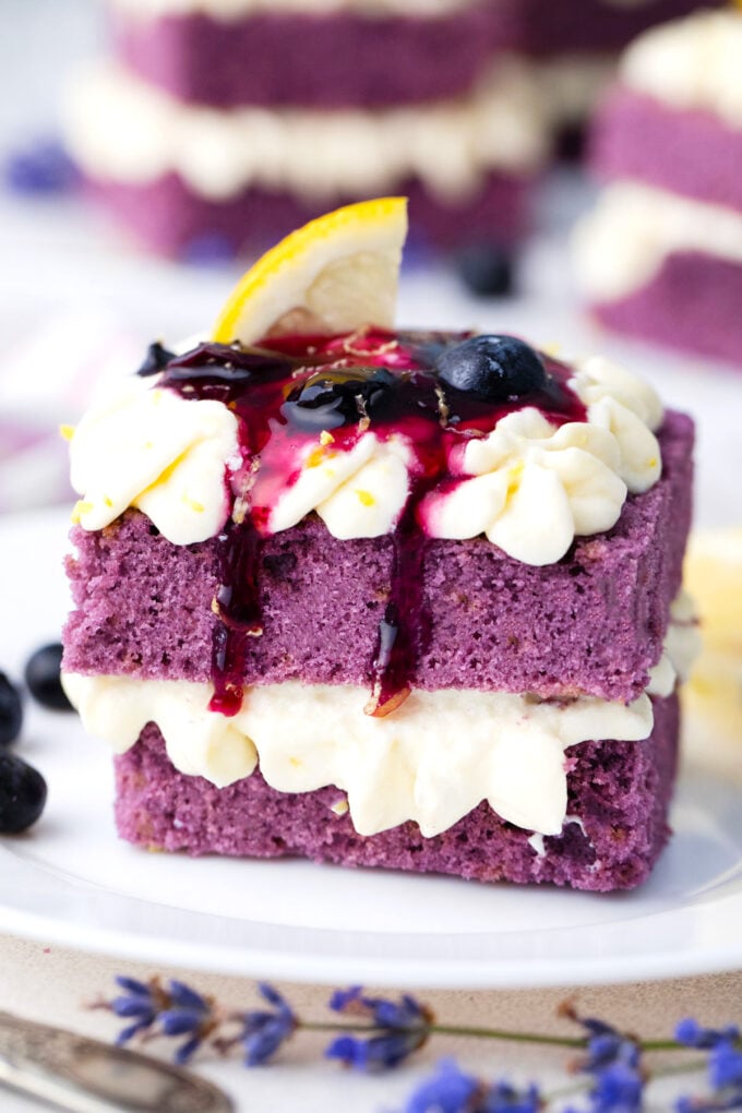 Purple cake topped with lemon buttercream and blueberry sauce.