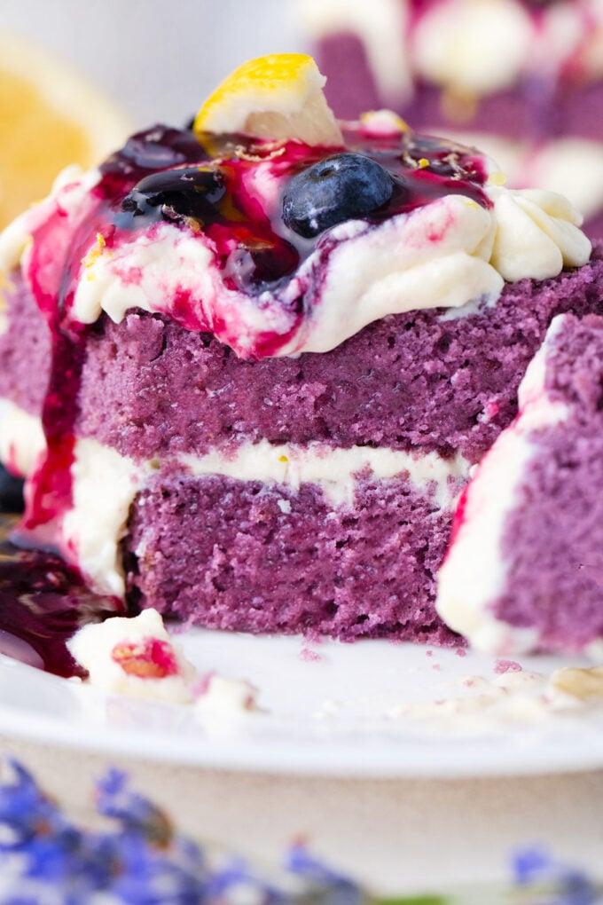 Sliced purple cake topped with lemon buttercream.