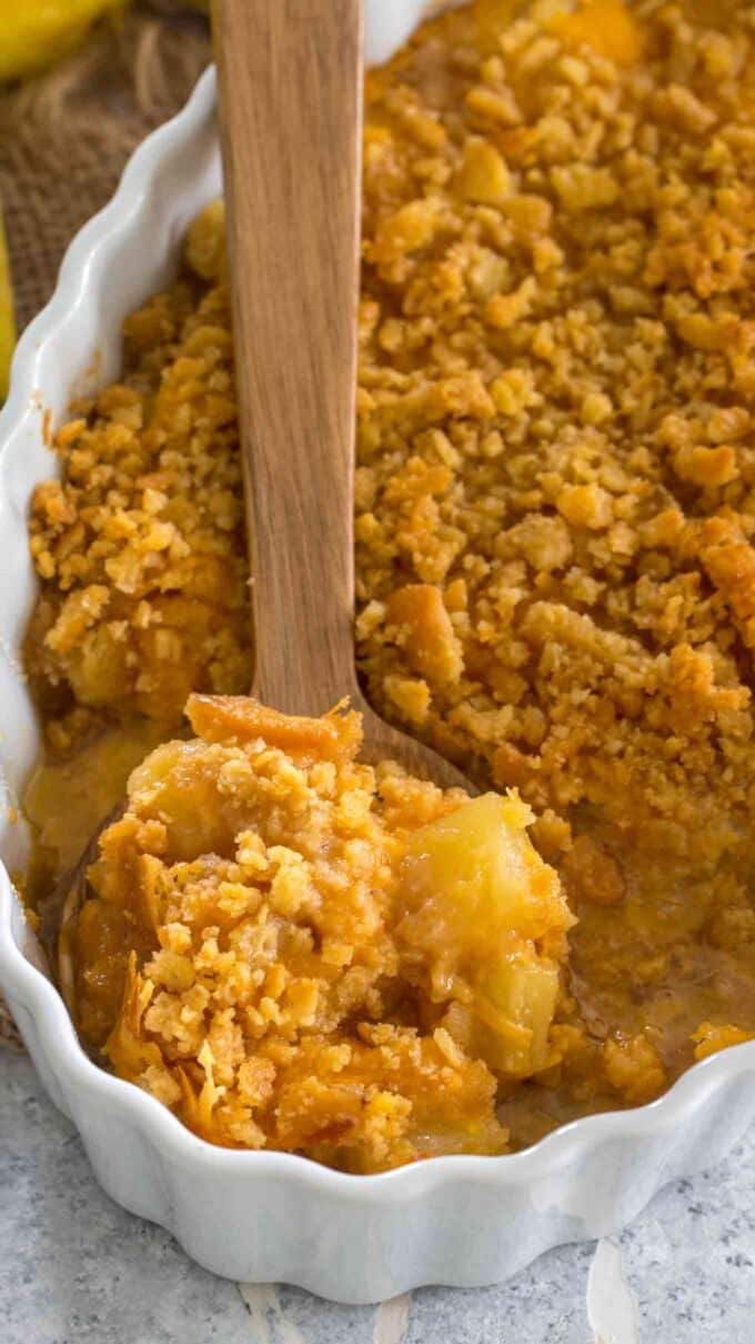 Picture of pineapple casserole on a wooden spoon.