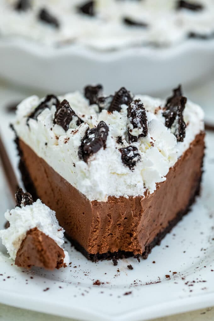 Image of a slice of no bake chocolate pie on a white plate.