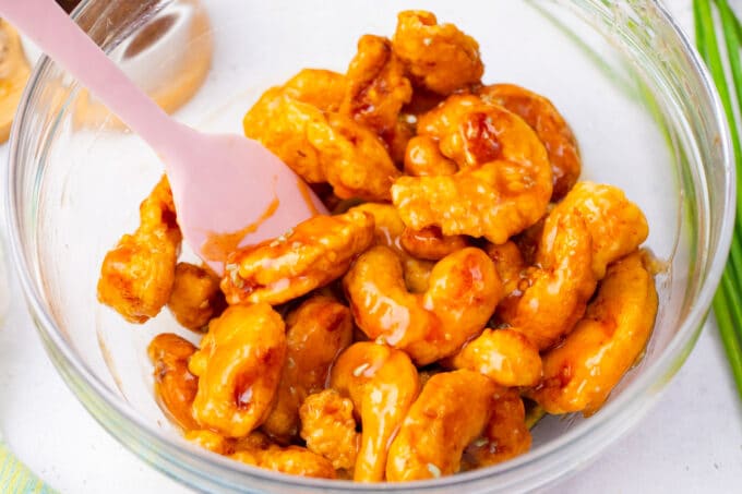 Coating fried shrimp into honey garlic sauce.