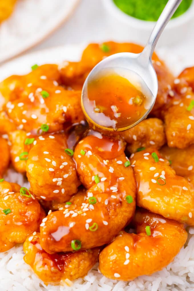 Drizzling honey garlic sauce on top of crispy fried shrimp.