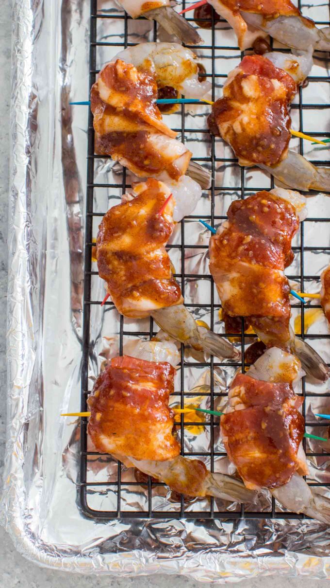 raw Bacon Wrapped Shrimp with Brown Sugar on a wire rack on top of a baking sheet