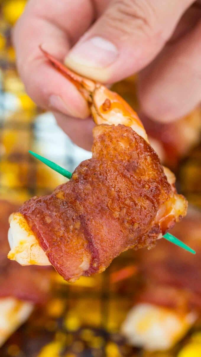 holding a crispy Bacon Wrapped Shrimp