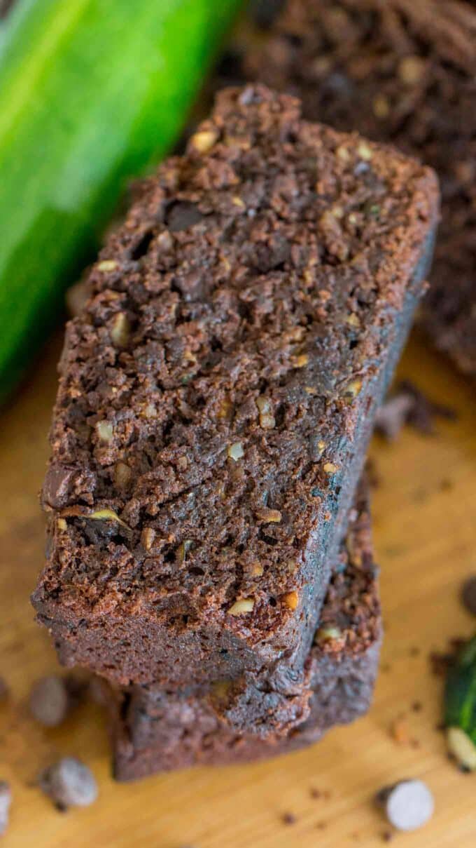 two sliced of chocolate zucchini bread on a wooden board