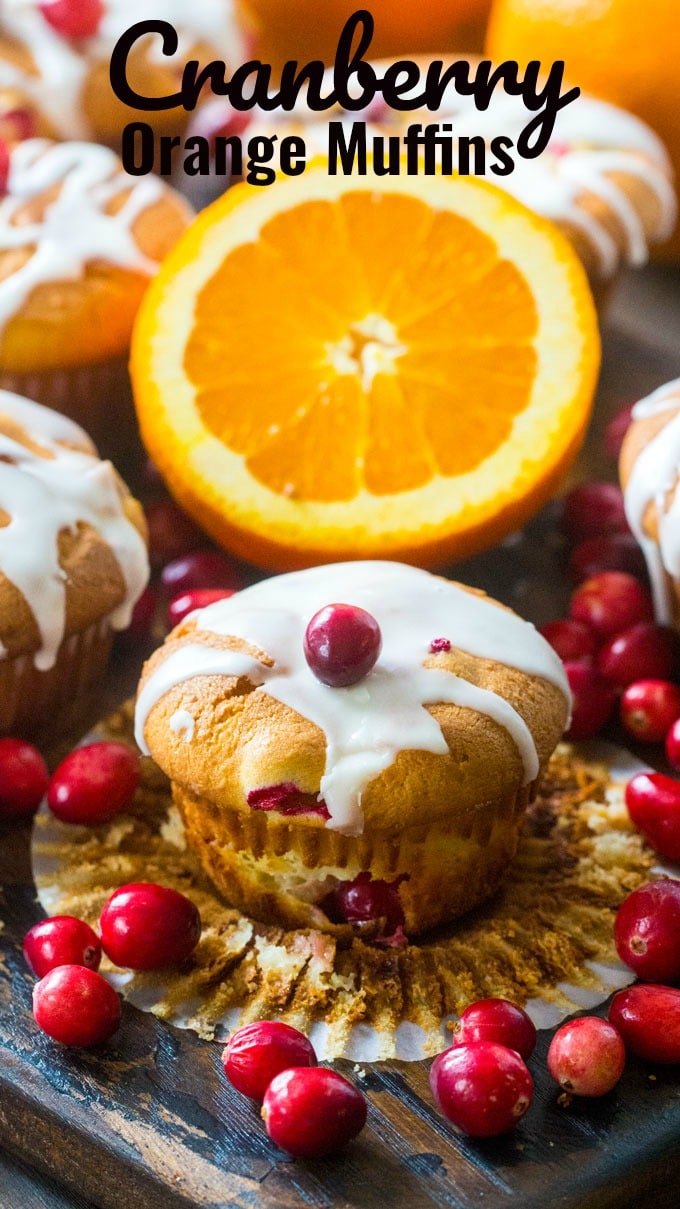 fluffy cranberry orange muffins with an orange half in the background