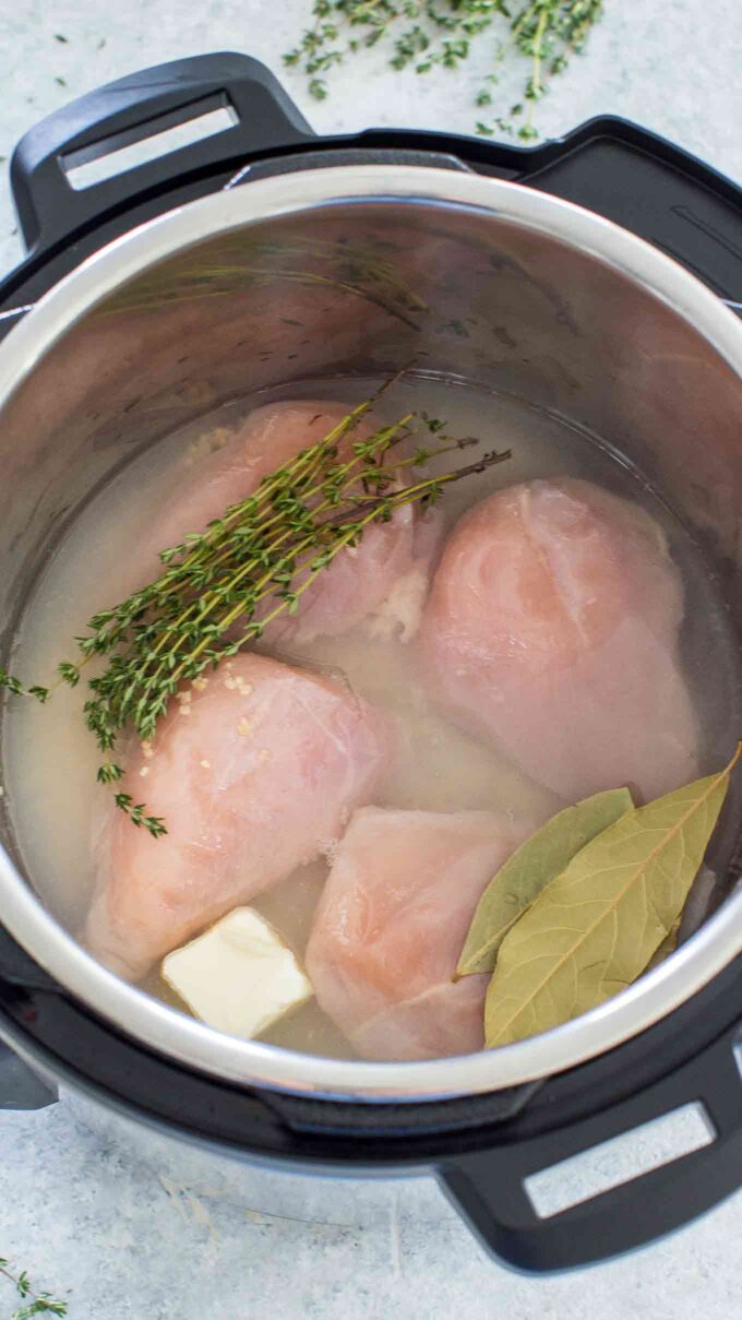 Frozen Chicken Breasts in the instant pot with liquid, herbs and butter