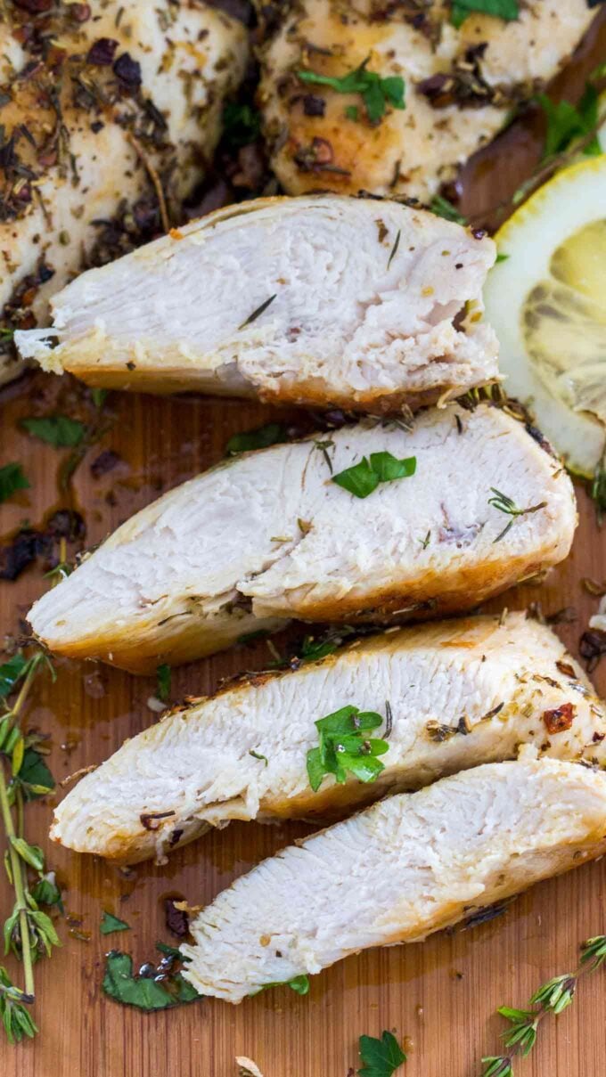 sliced herbed chicken breast on a cutting board