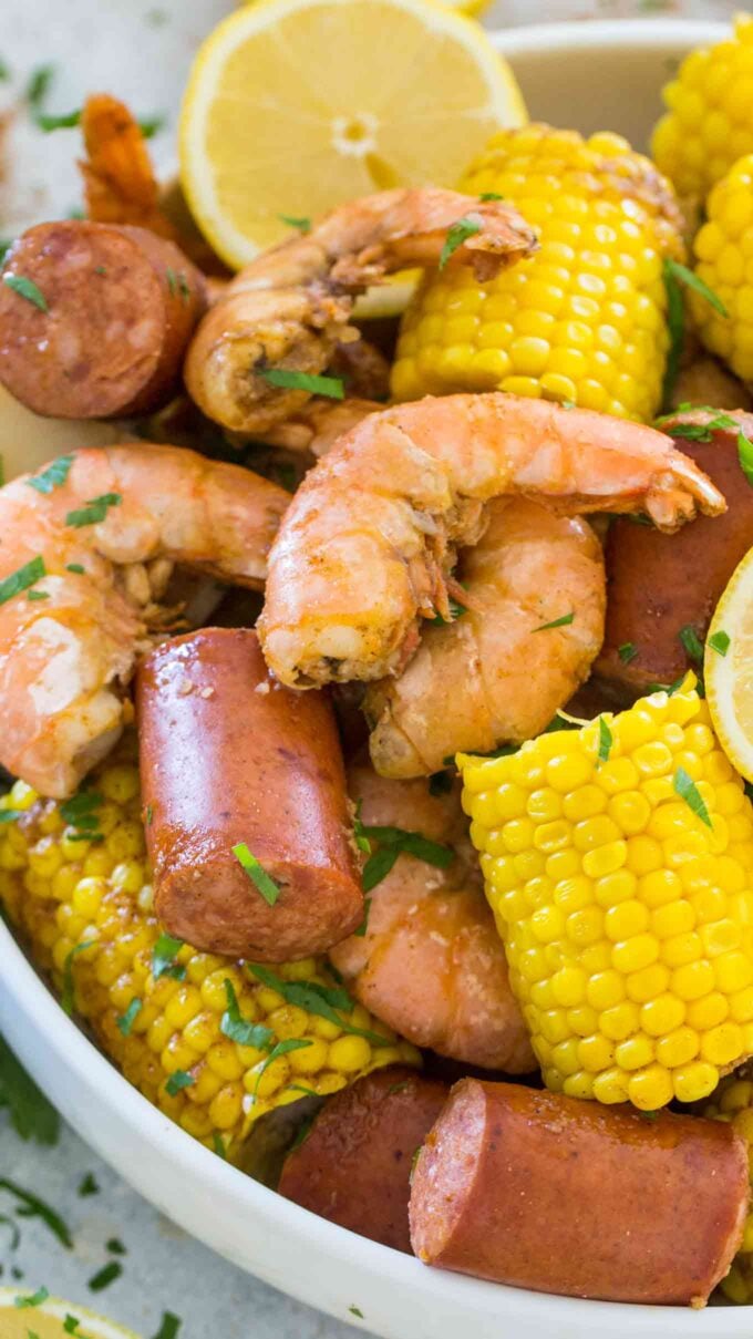 Instant pot shrimp boil with corn sausage and lemon in a white bowl