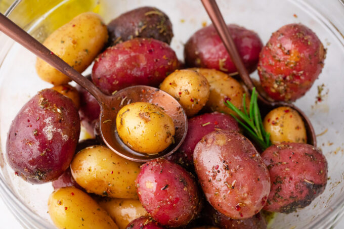 Seasoning baby potatoes.