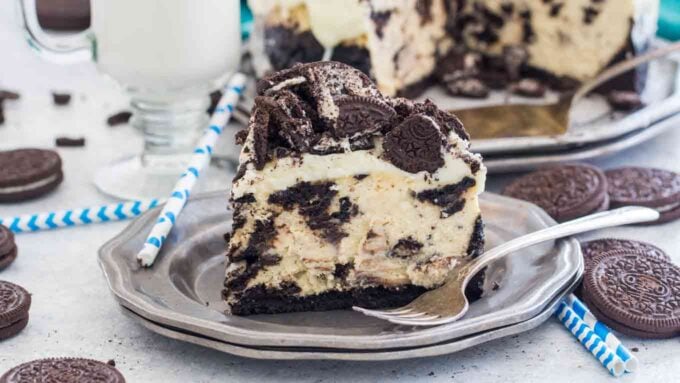 Image of a slice of oreo cheesecake on a silver plate. 