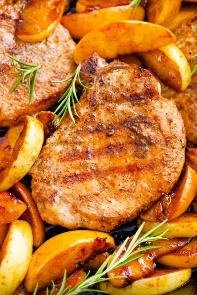 apple cinnamon pork chops with apple slices and fresh rosemary