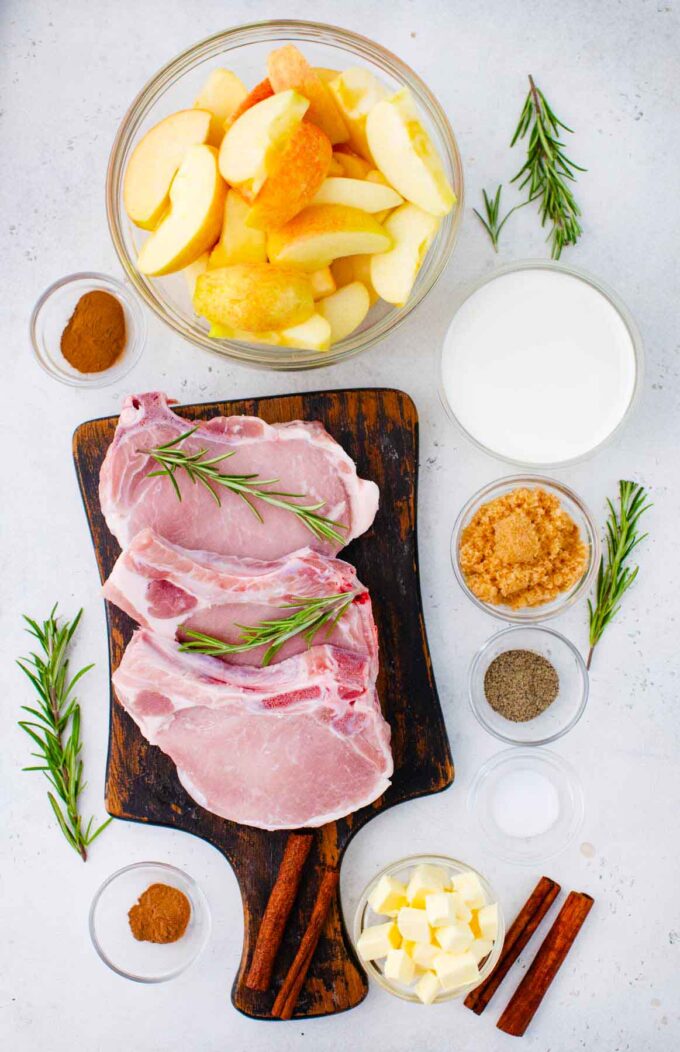 apple cinnamon pork chops ingredients in bowls around a cutting board with bone-in pork chops