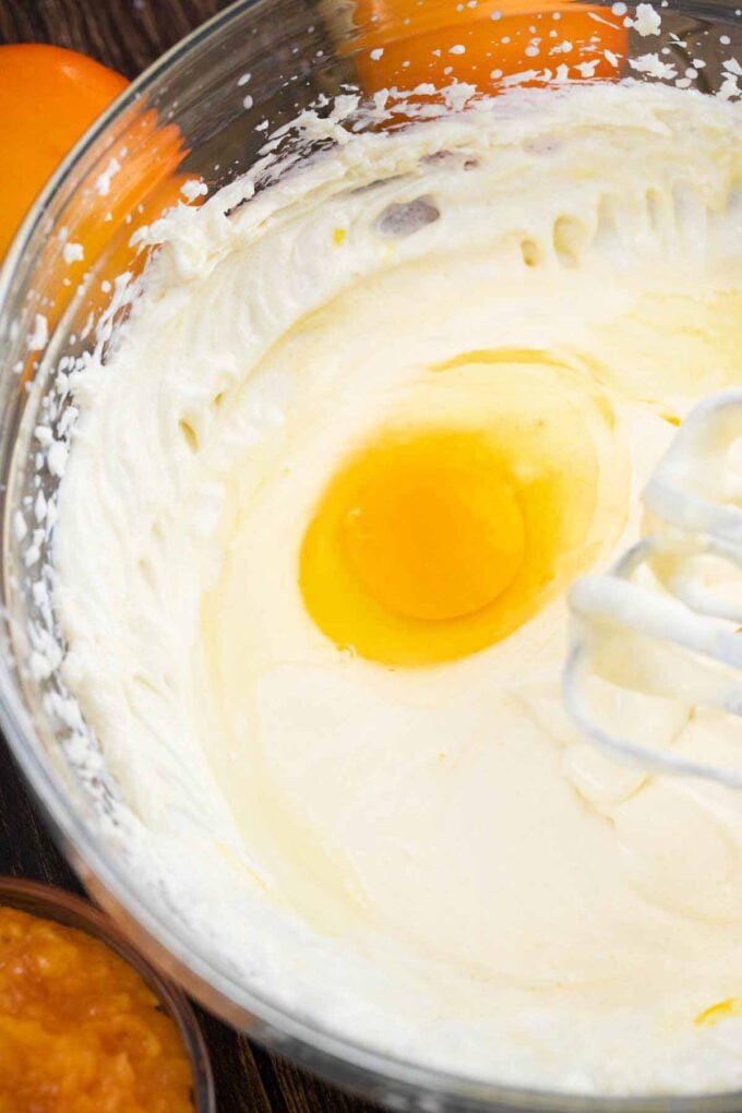 adding egg to cheesecake batter