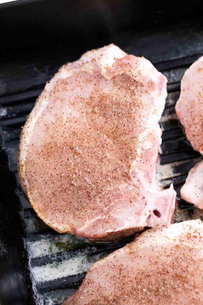 cooking seasoned pork chops in a cast iron skillet