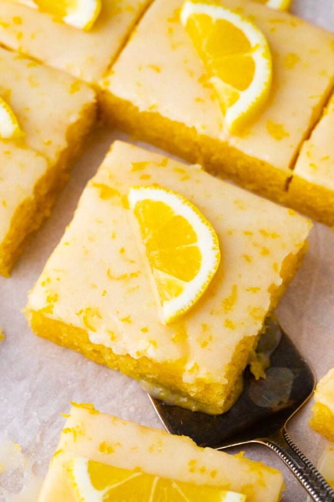 Lemon brownies topped with lemon glaze and a slice of lemon.