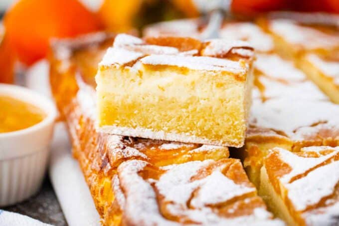 persimmon cheesecake pound cake bars topped with powdered sugar