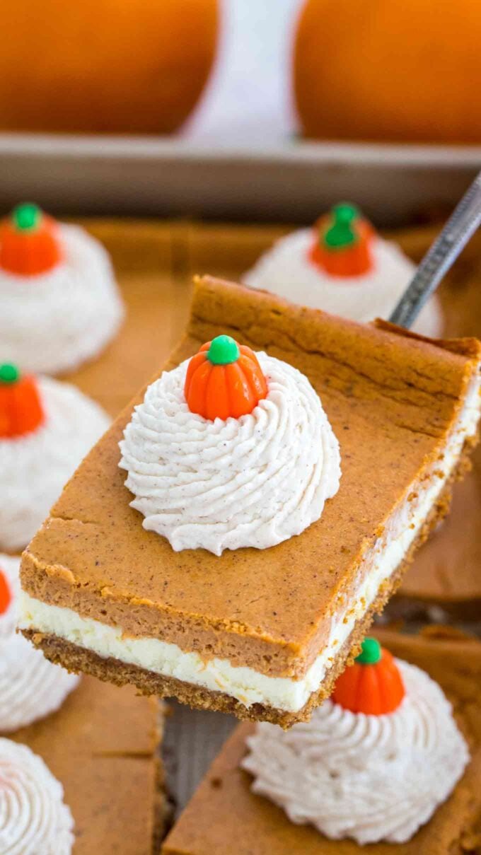 Pumpkin cheesecake bars on a serving spatula