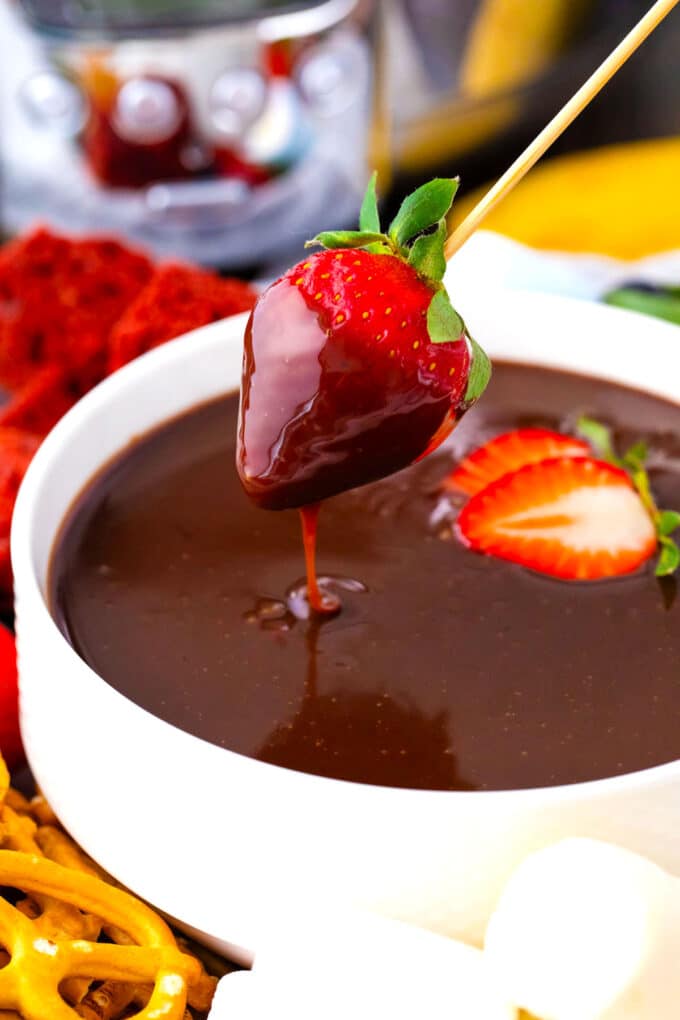 Dipping a strawberry in crockpot chocolate fondue.