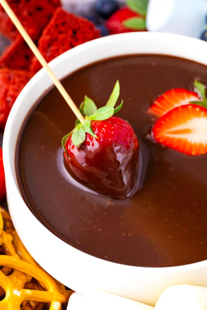 A strawberry dipped into slow cooker chocolate fondue.