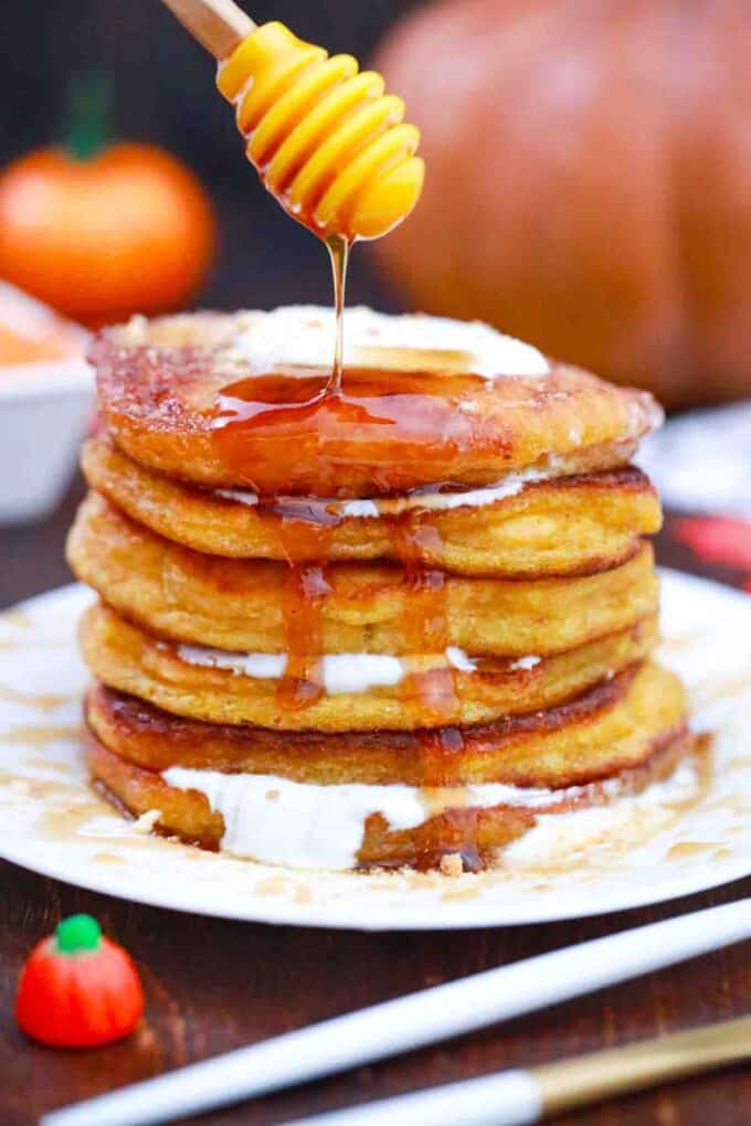 drizzling pumpkin pancakes with maple syrup