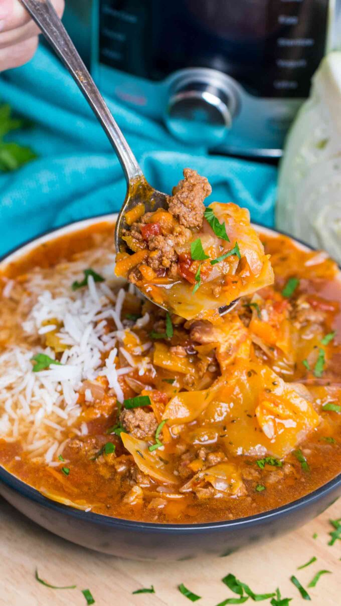 taking a spoonful of Instant Pot Cabbage Roll Soup with ground beef and bacon