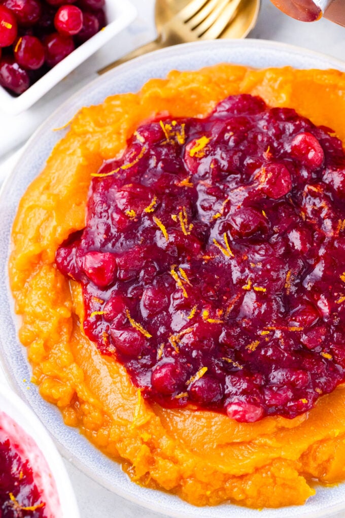Overhead shot of Instant Pot cranberry sauce over sweet mashed potatoes.