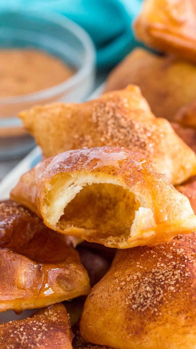 a homemade sopapillas with a bite in it revealing an empty center and crispy top