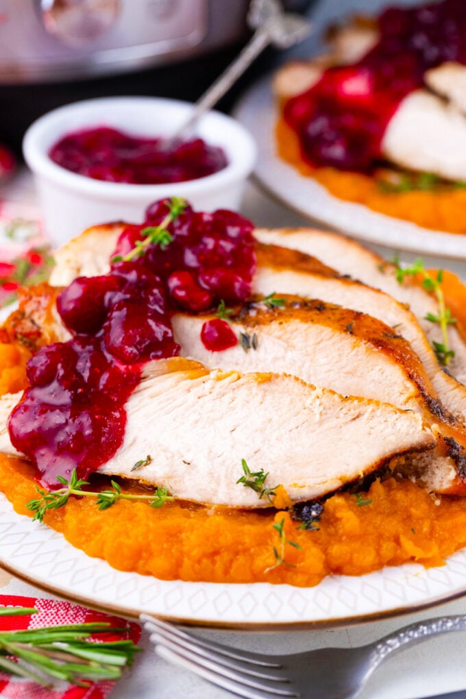 Instant pot turkey breast sliced and served with cranberry sauce and mashed sweet potatoes.