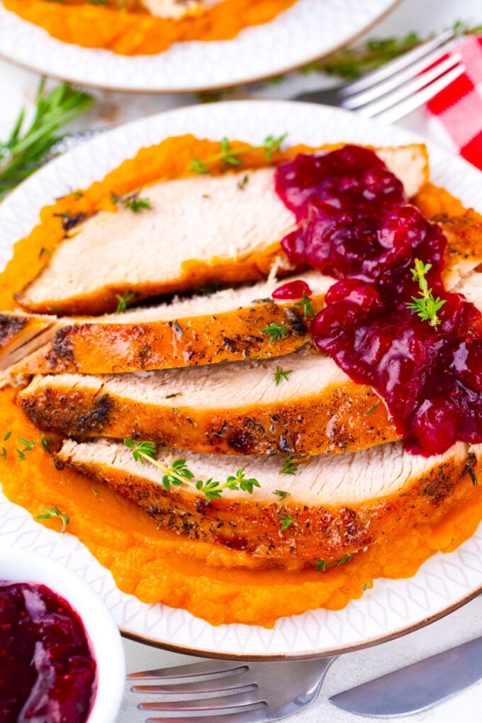 Overhead shot of Instant pot turkey breast sliced and served with cranberry sauce and mashed sweet potatoes.
