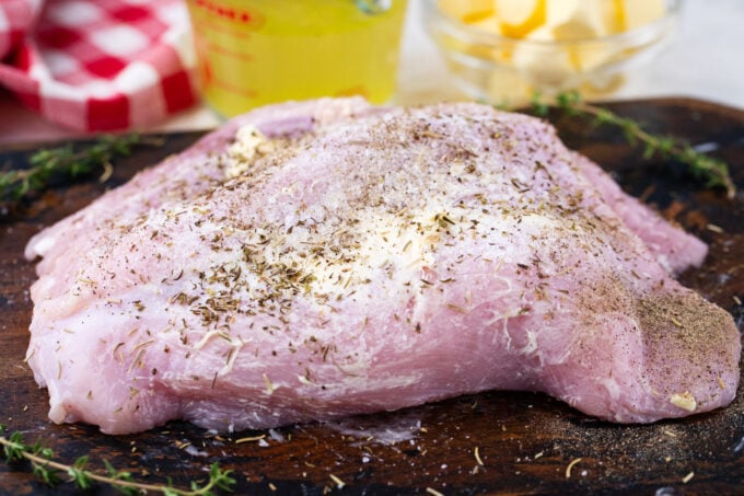 Seasoned turkey breast on a cutting board.
