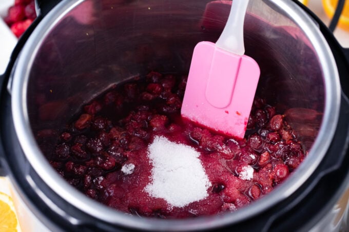 Stirring sugar into Instant Pot cranberry sauce.