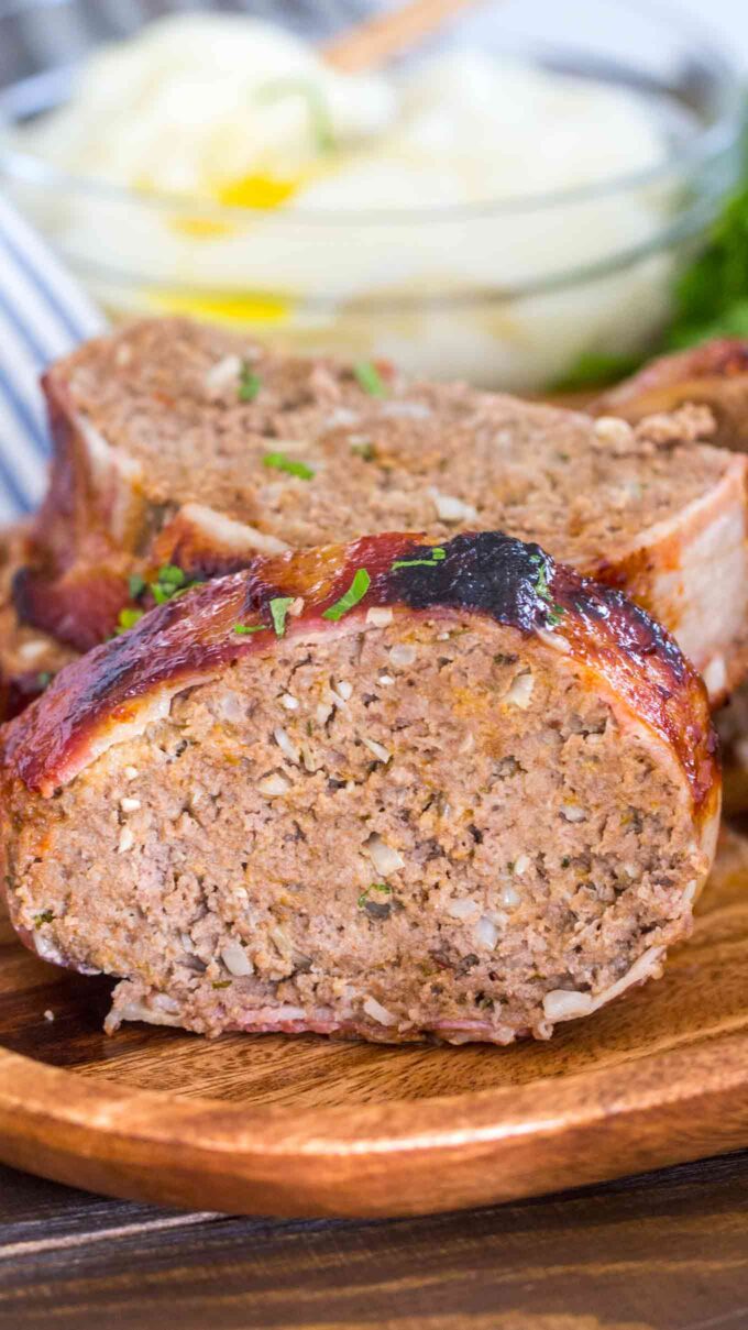 Sliced bacon wrapped meatloaf on a wooden board